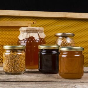 Pack de miels naturels artisanaux présentés avec des fleurs et des éléments de santé, mettant en avant les bienfaits pour l'immunité